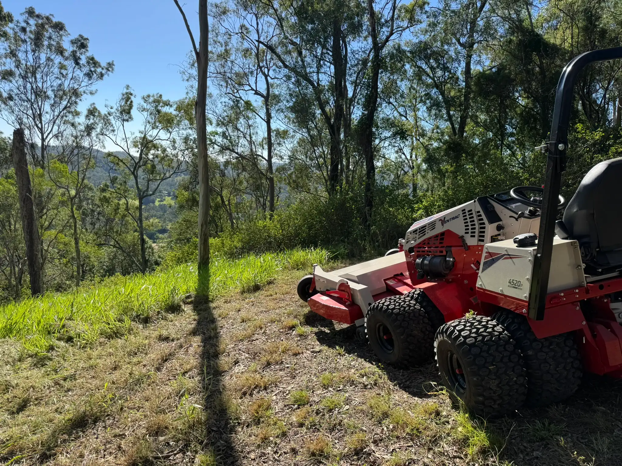 Ventrac 4520P mowing a steep slope above a valley in Pullenvale